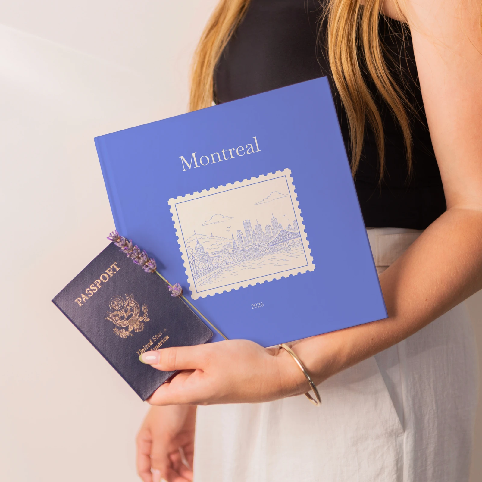 A blue Montreal Travel Book held next to a passport